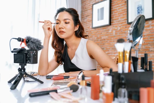 Woman influencer shoot live streaming vlog video review makeup uttermost social media or blog. Happy young girl with cosmetics studio lighting for marketing recording session broadcasting online.