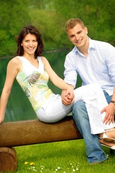 Happy couple in park by lake