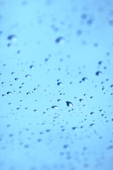 Water drops on glass with blue sky