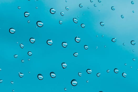 Water drops on glass with blue sky