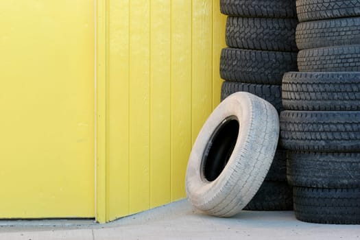 stack of tires against yellow wall