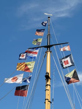 Colorful flags on a mast in front of sky