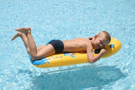 Boy on air mattress in pool