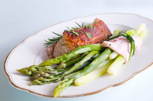 Pork tenderloin with green asparagus on Tel