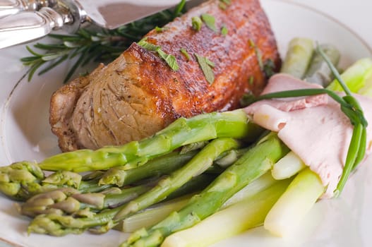 Pork tenderloin with green asparagus on Tel