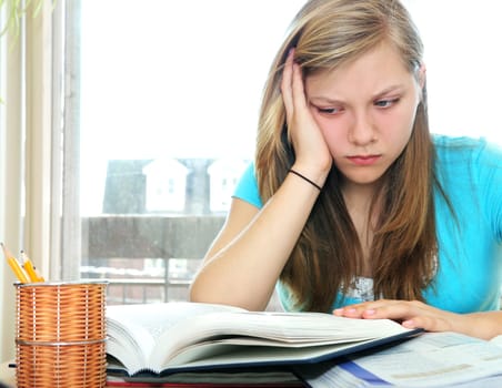Teenage girl studying with textbooks