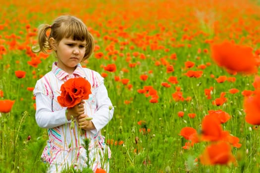Girl on meadow with a red poppies