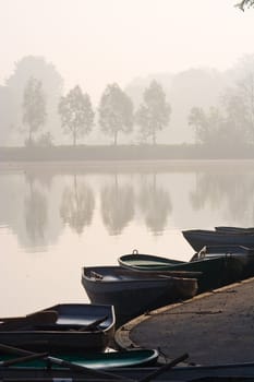 Rowing boats at misty pond