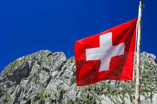 Swiss flag in front of a rock face