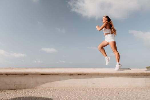 Fitness woman sea. Outdoor workout on yoga mat in park near to ocean beach. Female fitness pilates yoga routine concept. Healthy lifestyle. Happy fit woman exercising with rubber band in park.