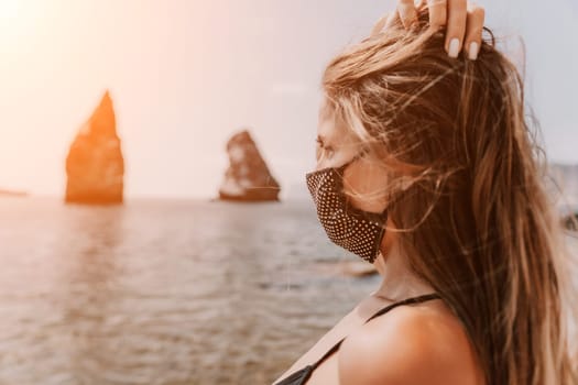 Woman travel sea. Young Happy woman in a long red dress posing on a beach near the sea on background of volcanic rocks, like in Iceland, sharing travel adventure journey