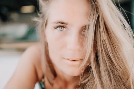 Happy woman portrait in cafe. Boho chic fashion style. Outdoor photo of young happy woman with long hair, sunny weather outdoors sitting in modern cafe