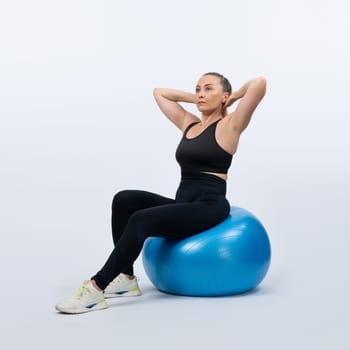 Full body length shot athletic and sporty senior woman with fitness exercising ball on isolated background. Healthy active and body care lifestyle after retirement. Clout