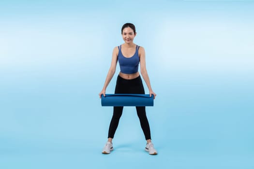 Young attractive asian woman portrait in sportswear with exercising mat. Healthy exercise and workout routine lifestyle concept. Studio shot isolated background. Vigorous