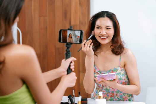 Woman influencer shoot live streaming vlog video review makeup uttermost social media or blog. Happy young girl with cosmetics studio lighting for marketing recording session broadcasting online.