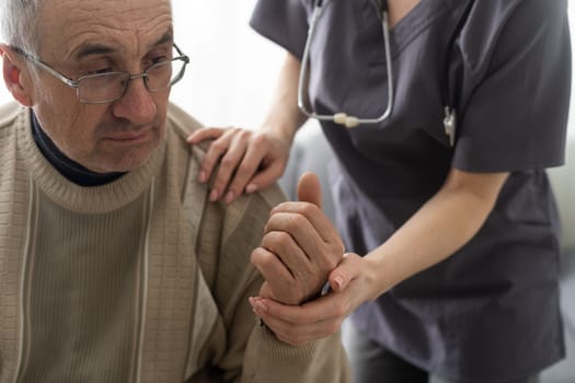 Nurse holding hand of senior man in rest home