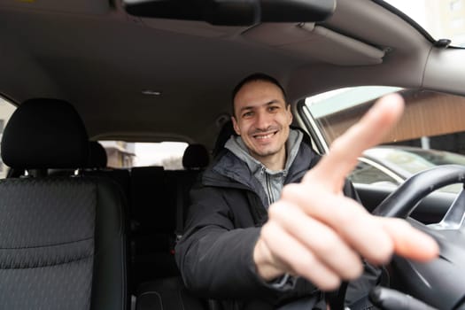 Joyful indian man driving car, shot from dashboard, going on trip during summer vacation, copy space. Happy middle-eastern guy in casual outfit and glasses driving his brand new nice car. High quality photo