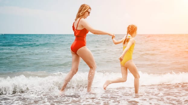 Happy loving family mother and daughter having fun together on the beach. Mum playing with her kid in holiday vacation next to the ocean - Family lifestyle and love concept.