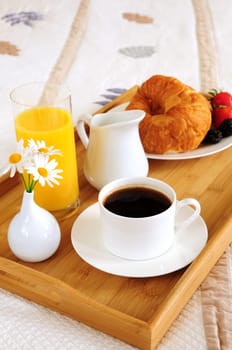 Breakfast on a bed in a hotel room