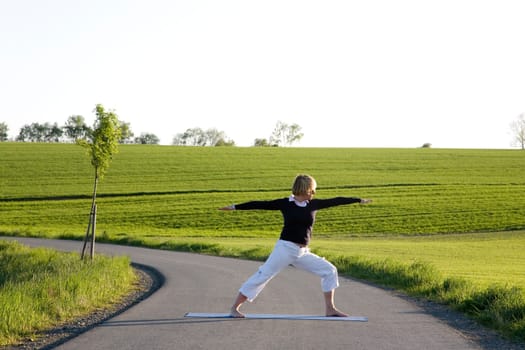 Woman doing yoga exercise - The Warrior I
