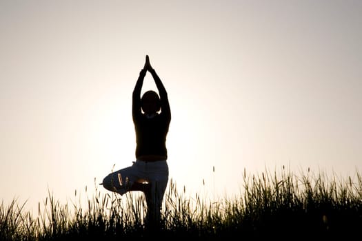 Woman doing yoga exercise - the tree