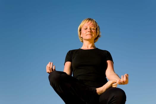 Woman doing yoga exercise - half lotus position