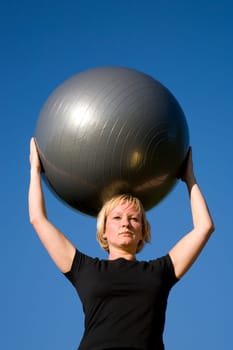 Woman with ball doing sports exercises