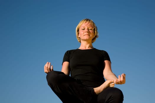 Woman doing yoga exercise - half lotus position