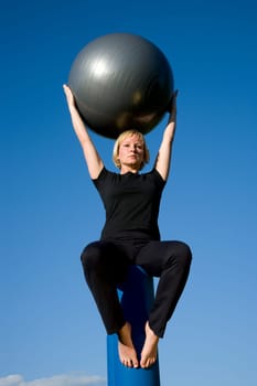 Woman with ball doing sports exercises