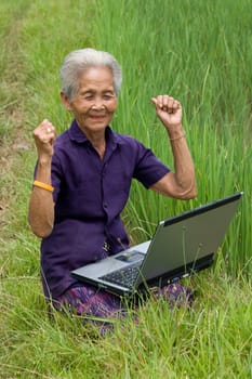Old Asian woman with laptop