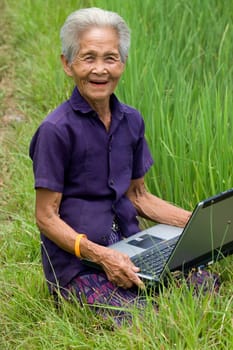 Old Asian woman with laptop