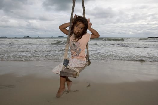 Girl on swing by the sea