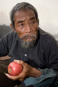 Old asian man with apple