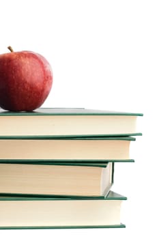 A red apple on top of many books
