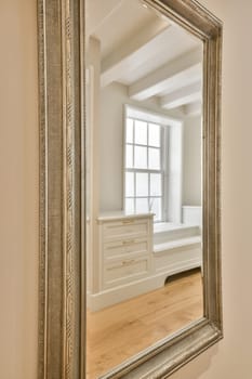 a large mirror in the corner of a room with white walls and hardwood flooring on the other side of the frame