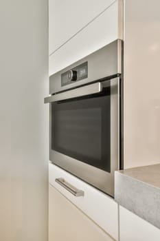 a modern kitchen with white cabinets and stainless steel appliances in the photo is taken to the right, showing the oven
