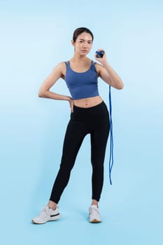 Young energetic asian woman in sportswear with jumping or skipping robe posing portrait in studio shot on isolated background. Cardio exercise tool and healthy body care lifestyle. Vigorous