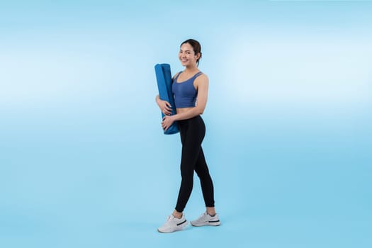 Young attractive asian woman portrait in sportswear with exercising mat. Healthy exercise and workout routine lifestyle concept. Studio shot isolated background. Vigorous