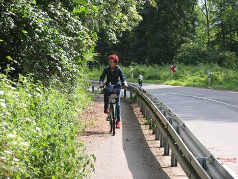 Woman on bicycle next to road