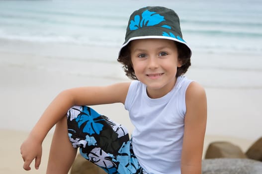 Pretty boy sitting on the beach