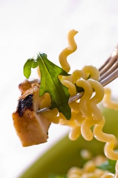Pasta salad with chicken breast on fork
