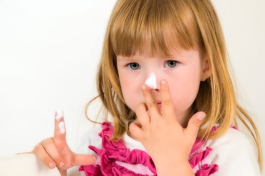 little girl with cream on the nose