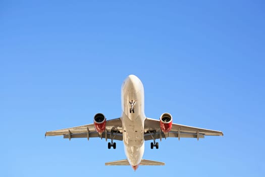 airplane overhead against blue sky