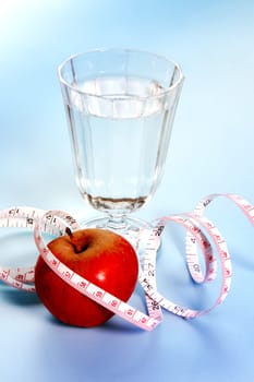 Water glass and tape measure with apple