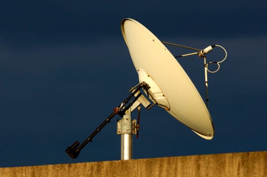 Satellite antenna on a roof against a dark thunderstorm sky