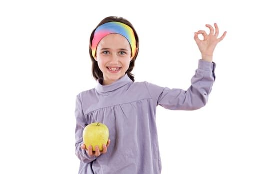 Adorable girl with a apple saying OK