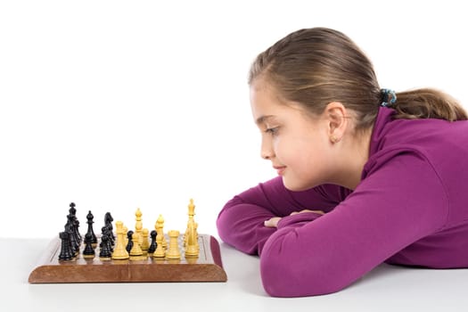 Attractive little girl playing chess