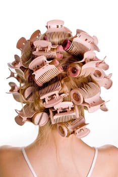 Young beautiful girl is having hair curlers on her head
