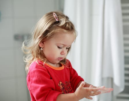 Small girl washing her hands