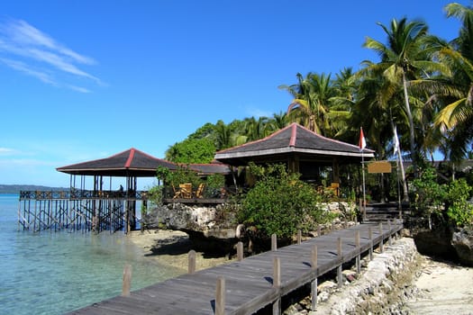 Small island in Asia with stilt restaurant.